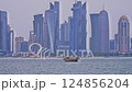 Doha, Qatar-March 16 2025:Doha Qatar skyline from corniche promenade sunset shot showing dhows in Arabic gulf with Qatar flag 124856204