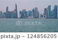 Doha, Qatar-March 16 2025:Doha Qatar skyline from corniche promenade sunset shot showing dhows in Arabic gulf with Qatar flag 124856205