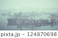 Misty harbor with abandoned ships at dawn in a tranquil waterway 124870698