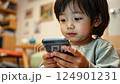 asian boy looking at phone screen, japanese child with smartphone sitting on sofa, social media addiction, chinese kid playing on phone, technology, online shopping, internet 124901231