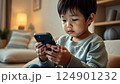 asian boy looking at phone screen, japanese child with smartphone sitting on sofa, social media addiction, chinese kid playing on phone, technology, online shopping, internet 124901232