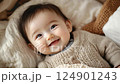 little cute smiling korean baby lying in crib, infant in cradle, asian child, kid, chinese newborn, childhood 124901243