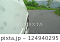 Beside white car goes on asphalt road. Trip travel to upcountry go with a green natural environment. atmosphere before rain. curve before going down the mountain. 124940295