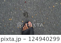 Video 4K : Above view of movement of the feet of a man in black sandals walking on the asphalt. 124940299