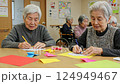 施設で折り紙をおっている老人女性たち 124949467