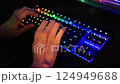 Womens hands type text on an RGB keyboard. Close up of pro cyber sport gamer play with RGB keyboard 124949688