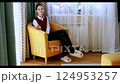 Young woman relaxing in bright room wearing comfortable clothes and slippers 124953257