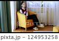 Young woman in cozy chair singing softly at home during sunny afternoon 124953258
