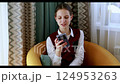 Young woman engaging with smartphone in cozy indoor setting during the afternoon 124953263