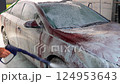 Washing a red car on a touchless car wash. Washing sedan car with foam and a high pressure water 124953643
