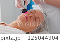 Woman Getting Fractional Microneedle RF Face Lifting Procedure in Beauty Salon 125044904
