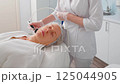 Woman Getting Fractional Microneedle RF Face Lifting Procedure in Beauty Salon 125044905