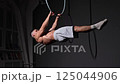 Muscular man performing abs workout, highlighting his well-defined six-pack 125044906