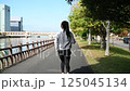 川沿いの歩道をウォーキングするかっこいい笑顔の女性の後ろ姿　ダイエット　歩く　運動　※手振れ多 125045134