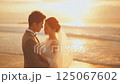 夕日につつまれた浜辺でのウェディングフォト 125067602