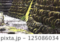 Mossy stone walls and sparkling stream 125086034