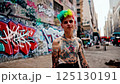 young person with Rainbow Hair & Tattoos Posing by Graffiti Wall - 4k Video extensive tattoos standing boldly in an urban alleyway. He wears alternative fashion, including earrings 125130191