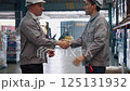 Warehouse supervisors and workers shaking hands to express their delight at working together. 125131932