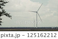 Wind turbines rotating in agricultural landscape under cloudy sky 125162212