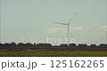 Wind turbines rotating in agricultural landscape under blue sky 125162265