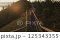 Woman walking down metal staircase on mountain at sunset 125343355