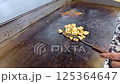 Cook preparing delicious grilled vegetables and chicken meat on a professional kitchen griddle, showcasing culinary skills and craftsmanship. Delicious ingredients and healthy cooking in action. 125364647