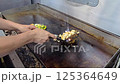 Cook preparing delicious grilled vegetables and chicken meat on a professional kitchen griddle, showcasing culinary skills and craftsmanship. Delicious ingredients and healthy cooking in action. 125364649