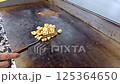 Cook preparing delicious grilled vegetables and chicken meat on a professional kitchen griddle, showcasing culinary skills and craftsmanship. Delicious ingredients and healthy cooking in action. 125364650