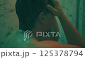 exhausted man taking shower in night 125378794