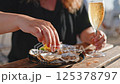 Woman pouring oysters lemon juice. 125378797