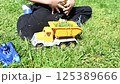 A child plays with toy cars on the lawn in the sunny day 125389666