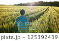 Golden Sunset Run: Boy Racing Through a Sunlit Wheat Field with a Stunning Sky 125392439