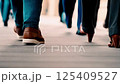 A group of people walking together, with the focus on their legs in motion 125409527