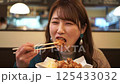 一名女子津津有味地吃著炸雞 125433032