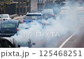 Heavy exhaust smoke from vehicles fills the busy street.AI Generated 125468251