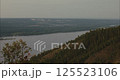 Contemplating vast river landscape and distant city from mountain peak 125523106