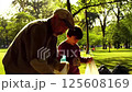 A father and son working together to collect garbage in a public park 125608169