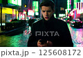 A young man looking at his phone with a shocked or concerned expression as he receives a notification with bad news 125608172
