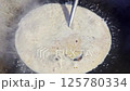 Asian cook is cooking in thai kitchen in local traditional country style, preparing sizzling thai green curry paste being stir fried in traditional wok to cook thai food green curry popular worldwide 125780334