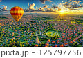 Hot air balloon floating over suburban residential area with church spire during golden sunset, aerial view of modern neighborhood with winding roads and red rooftops under sky 125797756
