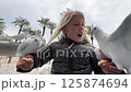Blonde girl feeding pigeons on a promenade 125874694