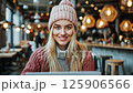 Young woman enjoying a cozy cafe atmosphere while working on her laptop 125906566
