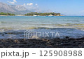 Sea waves against pebbles and stones on abBeach. Yachts at sea. Sea island on background. 125908988