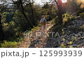 Young girl walking on a path at sunset in a forest 125993939