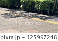 歩道に落ちる木陰と歩行者の足 125997246