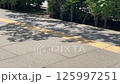 歩道に落ちる木陰と歩行者の足 125997251