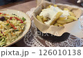 Enjoy a serving of crispy fries topped with creamy sauce alongside a refreshing Greek gabbage salad named politiki at a cozy local eatery in the evening. 126010138