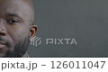Close-up portrait of calm African American man half face looking at camera on gray color background. Facial expression and emotion concept. 126011047