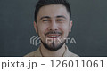 Slow motion portrait of joyful young biracial man laughing looking at camera on gray color background. People and positive emotion concept. 126011061