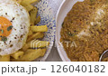 Overhead pan from savory orzo dish to crispy fries served with a fried egg on top. 126040182